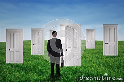 Businessman walking into opportunity doors