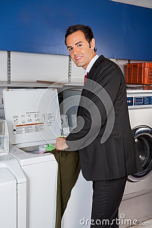 Businessman Washing Clothes At Laundromat