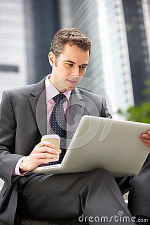 Businessman Working On Laptop Outside Office