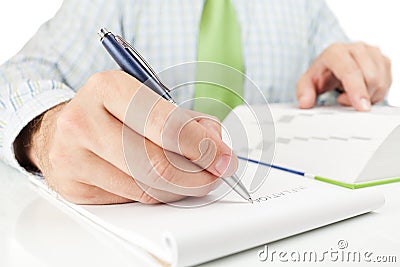 Businessman writing word INFLATION in notepad.