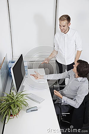 Businessmen pointing at computer screen in office