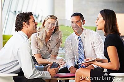 Businesspeople With Digital Tablet Having Meeting In Office