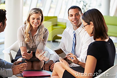 Businesspeople With Digital Tablet Having Meeting In Office