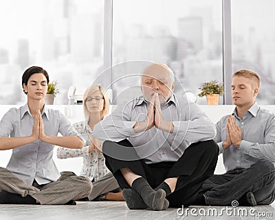 Businesspeople doing meditation in office