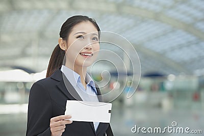 Businesswoman at the airport with airplane ticket