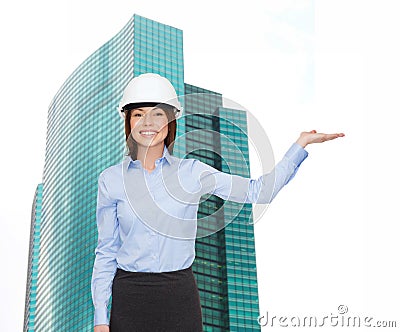 Businesswoman in helmet holding something on palm