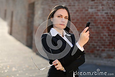 Businesswoman holding phone and glasses