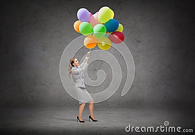 Businesswoman pulling down bunch of balloons