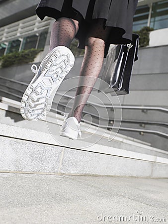 Businesswoman In Running Shoes Walking Up Steps