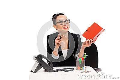 Businesswoman sitting in office chair and writing in notebook