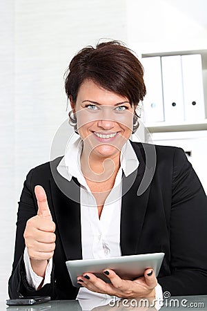 Businesswoman with tablet giving thumbs up