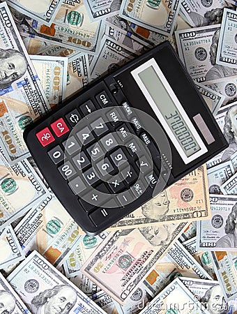 Calculator on background of hundred dollar bills