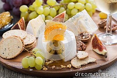 Camembert with honey and fruit, snacks on a wooden tray