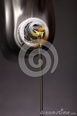 Can with car engine oil pouring black background