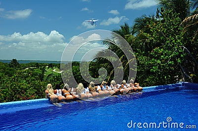 CANCUN, MEXICO - MAY 05: Models pose by the edge of pool for white t-shirt project