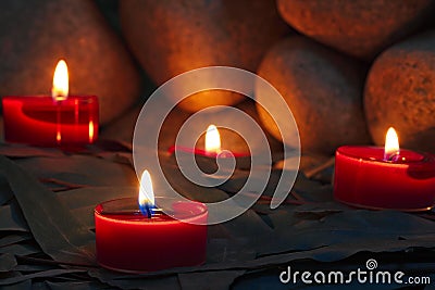 Candles are lit on the background of the stones.