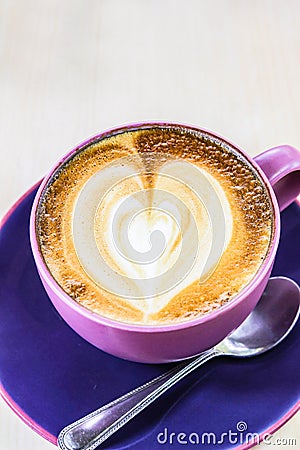 Cappuccino coffee with heart drawing in blue cup