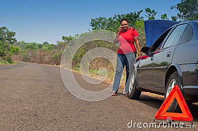 Car breakdown - African American woman call for help, road assistance.