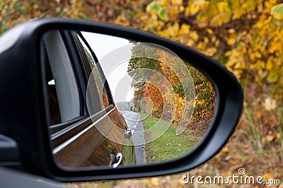 Car mirror autumn road reflection