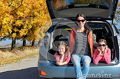 Car trip on autumn family vacation, happy mother and kids travel