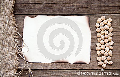 Card, chickpea, burlap and dark wood background