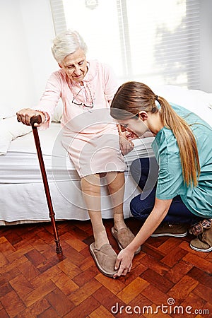 Caregiver helps dressing senior
