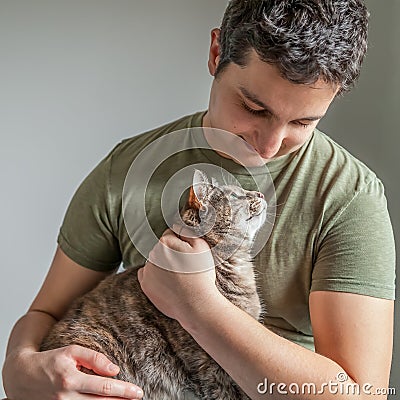 Caring Man Holding Cute Tortoiseshell-Tabby Cat