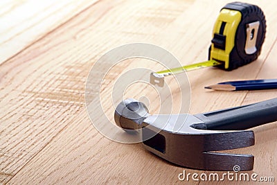 Carpenter Tools Hammer and Tape Measure on Wood