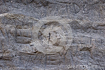 Carved Letters on Rough Gray Rock Wall Background Texture