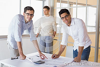 Casual architecture team working together at desk smiling at camera