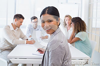 Casual businesswoman smiling at camera during meeting