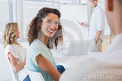 Casual businesswoman smiling at colleague during meeting