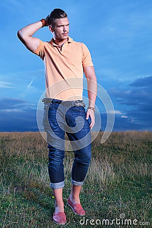 Casual man with hand at back of head, looks away