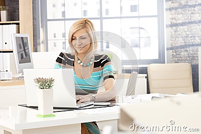 Casual secretary working with laptop computer