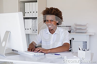 Casual smiling businessman in wheelchair working at his desk