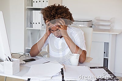 Casual stressed businessman with his head down at desk