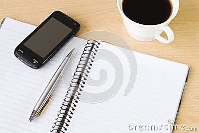 Cell phone, notebook and cup of coffee