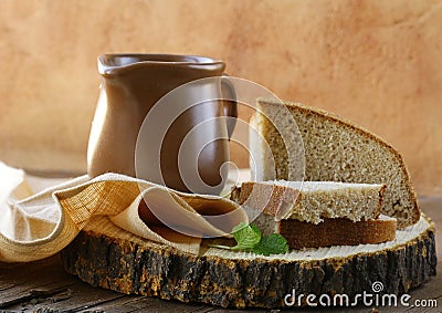 Ceramic jug with milk and a loaf rye black bread