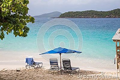 Chaise Lounges Under Blue Umbrella on Tropical Beach