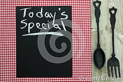 Chalkboard with Today s Special and cast iron spoon and fork