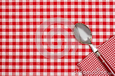 Checkered table cloth with red and white checks and a spoon