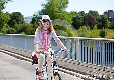 Cheerful blond woman riding a bicycle