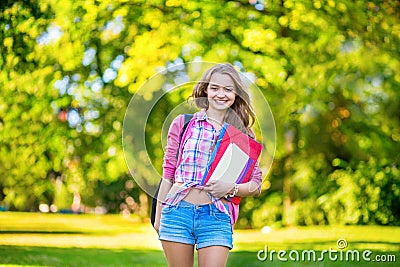Cheerful college student holding books and folders