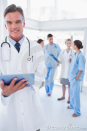 Cheerful doctor holding digital tablet