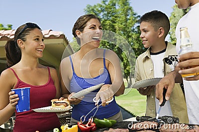Cheerful Family Around The Grill At Picnic
