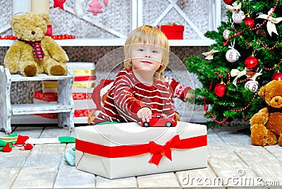 Cheerful little boy playing with his red toy car