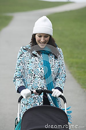 Cheerful Mother With Baby Stroller In Park