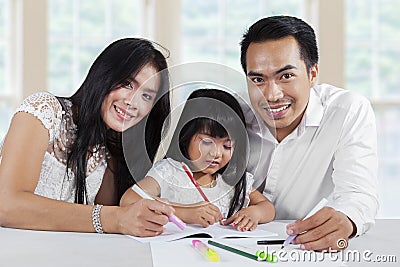 Cheerful parents help their child studying