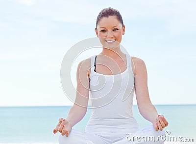 Cheerful woman doing yoga by the sea