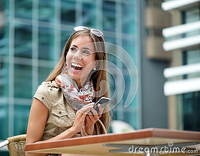 Cheerful woman smiling with mobile phone